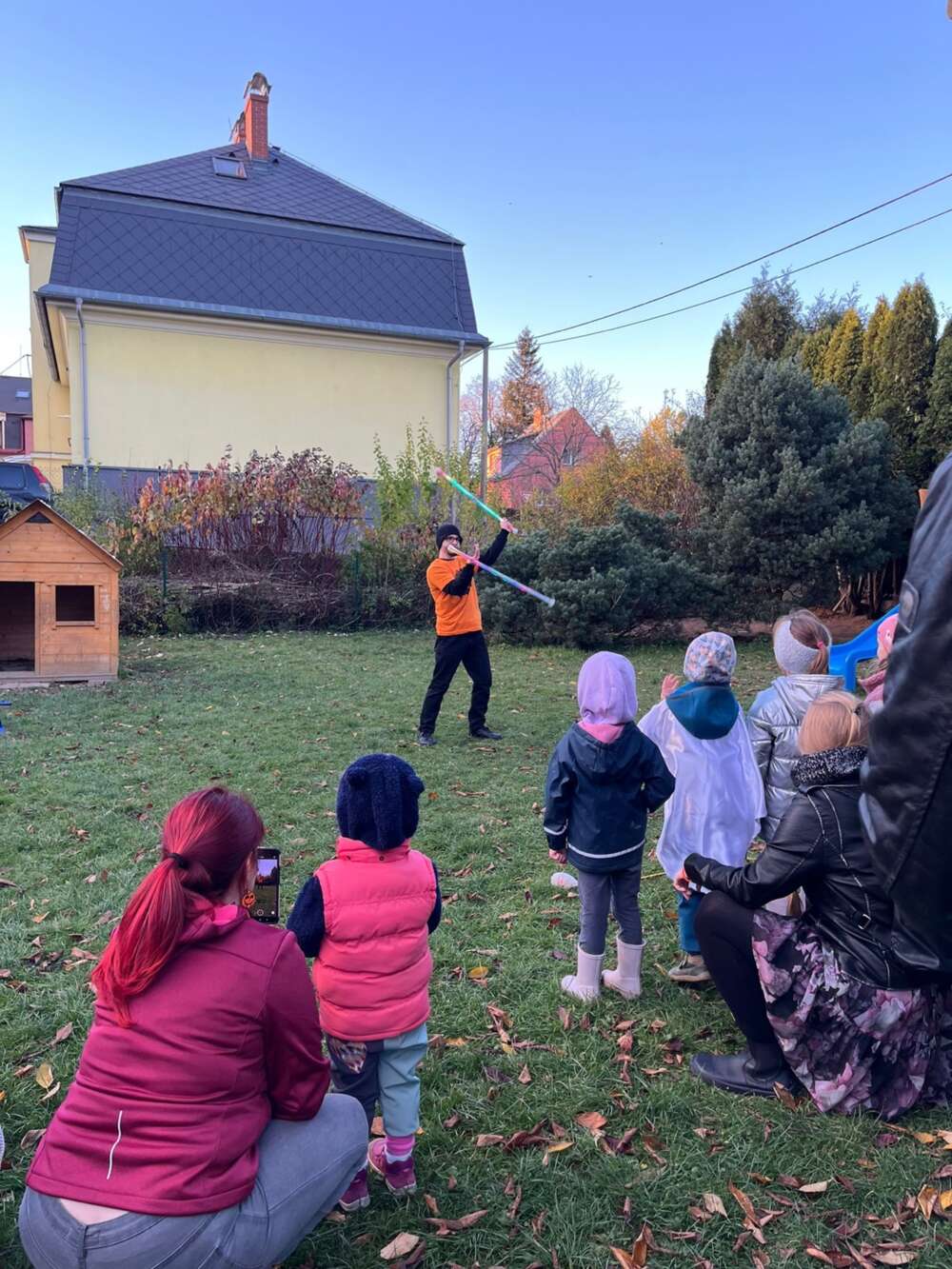 Matěj performing with LED staffs in front of children at a daycare